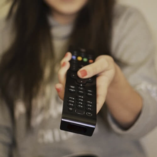 A Woman Holding A Television Remote Control