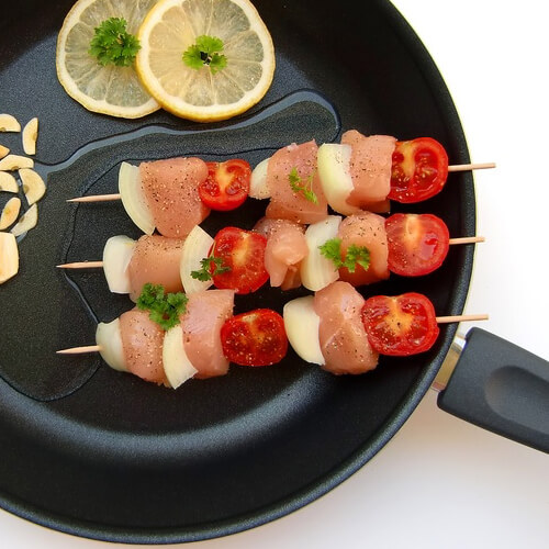 3 Raw Chicken Kebabs In A Frying Pan