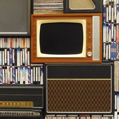 A Retro Television Surrounded By VHS Tapes