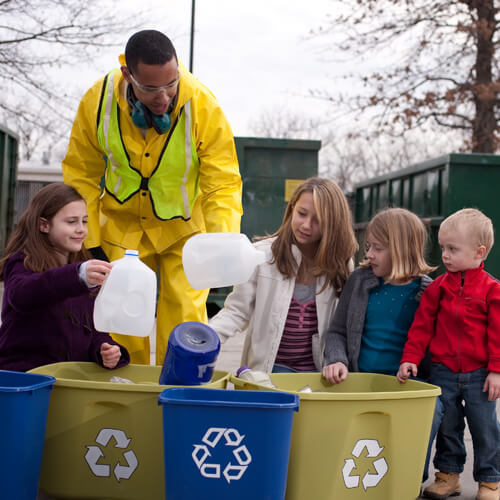 A Man In High Vis Showing Children How To Recycle