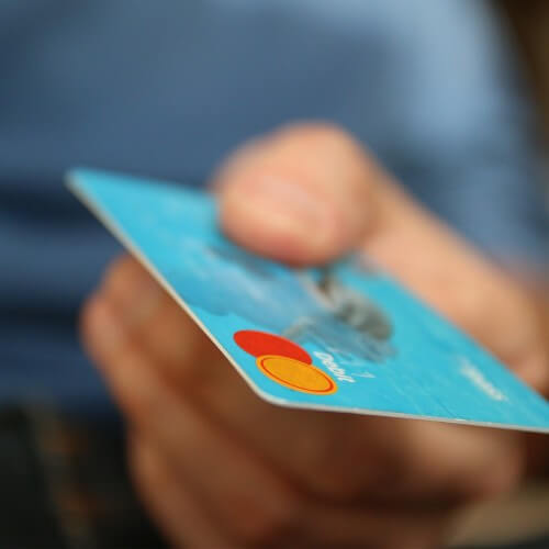 A Person Holding A Credit Or Debit Card