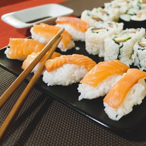 A Plate Of Salmon Sushi With Chopsticks