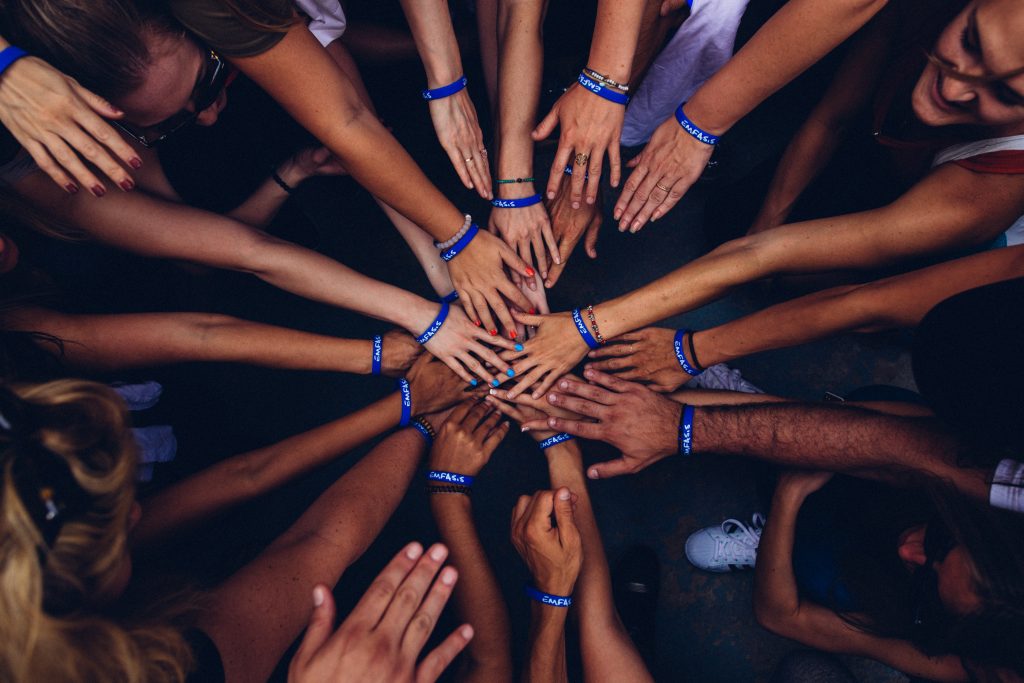 A Group Of Hands Being Placed On Top Of Each Other