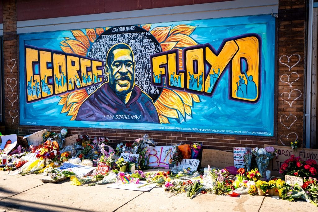 An Art Tribute To George Flloyd With Flowers Lay Next To It