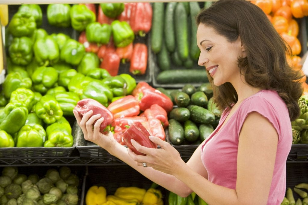 A Woman Picking A Vegetable Out From A Selection