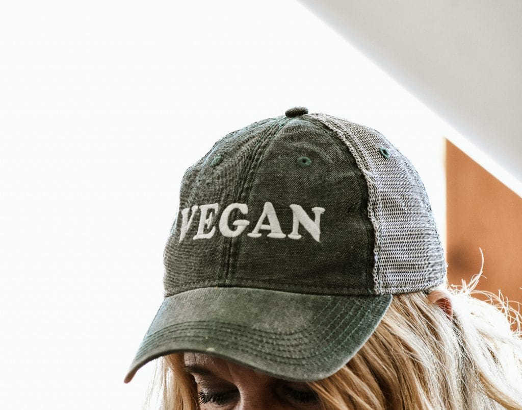 A Person Wearing A Cap With "Vegan" Written On It