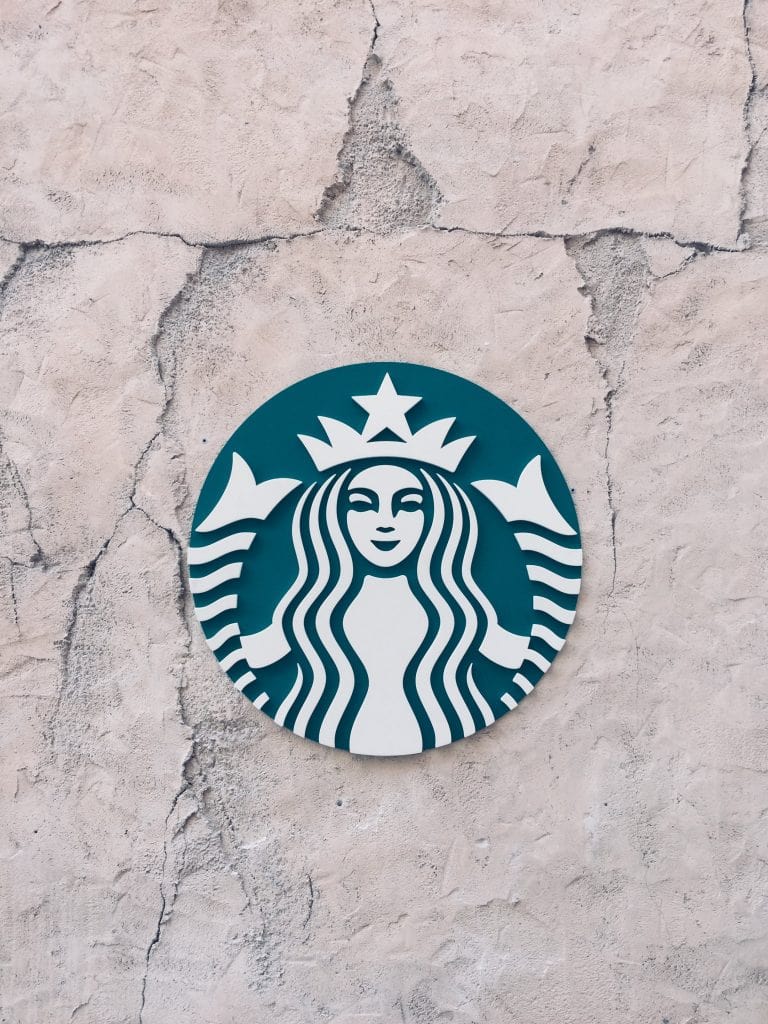 A Stone Wall With A Starbucks Logo On It