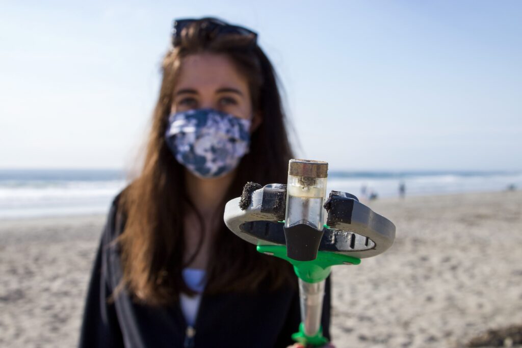 A Women On The Beach Holding A Sample